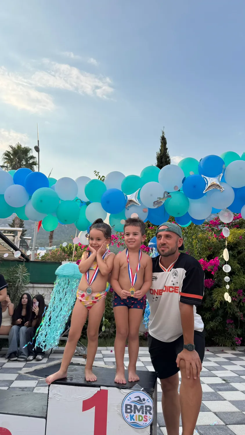 BMR Kids yüzme yarışması ödül töreni, madalyalı öğrenciler kürsüde